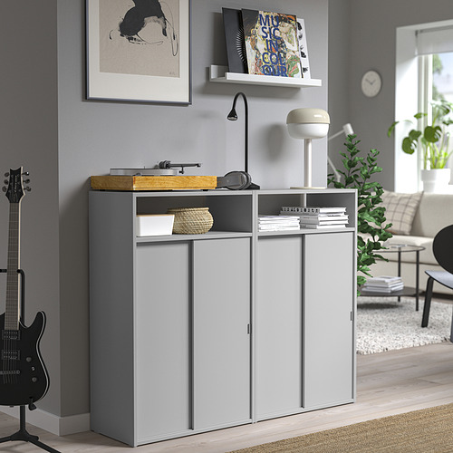 Sala de estar moderna con gabinete SPIKSMED gris, almacenamiento abierto y cerrado, tocadiscos, guitarra y sofá.