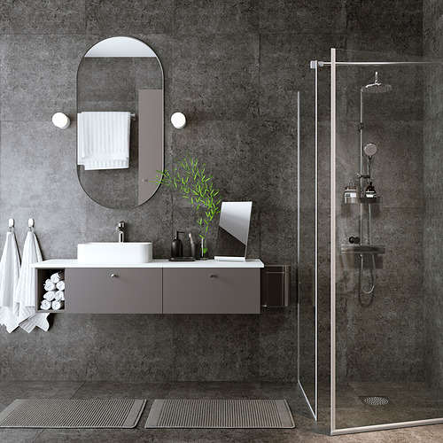 Baño moderno con decoración gris y negra, espejo ovalado, tocador flotante y cabina de ducha de vidrio con cabezal de ducha tipo lluvia.