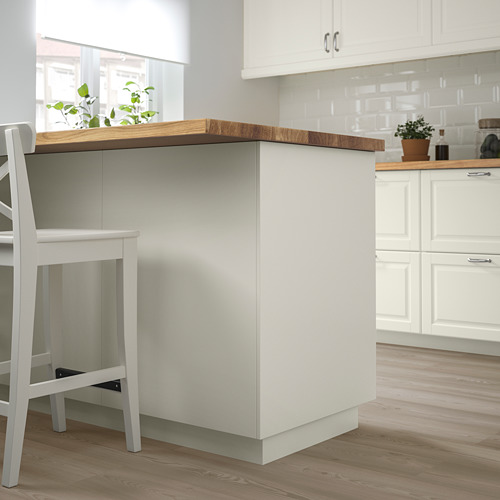 Moderna isla de cocina FÖRBÄTTRA blanca con encimera de madera clara, planta pequeña y taburete blanco. Diseño limpio y minimalista.