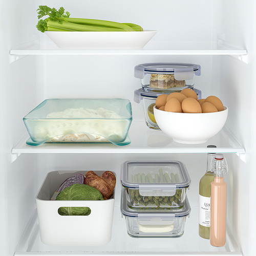 Contenido del refrigerador bien organizado con frutas frescas, verduras y recipientes de alimentos.