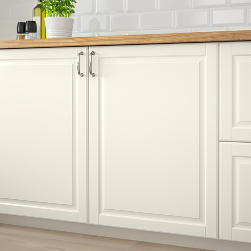 Armarios de cocina blancos con encimera de madera. Superficies lisas lacadas en blanco roto para facilitar la limpieza. Manillas cromadas en la puerta izquierda.