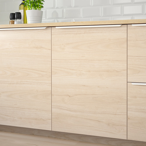 Armarios de cocina con efecto madera de fresno claro, superficie de melamina de fácil limpieza, montados con puertas reversibles.