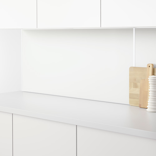 Encimera de cocina minimalista con panel de pared blanco LYSEKIL que protege una superficie limpia y elegante.