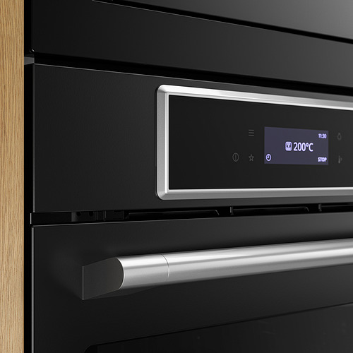 Horno moderno negro con pantalla digital que muestra 200°C y un asa plateada elegante, lo que indica diseño de alta calidad y control preciso.