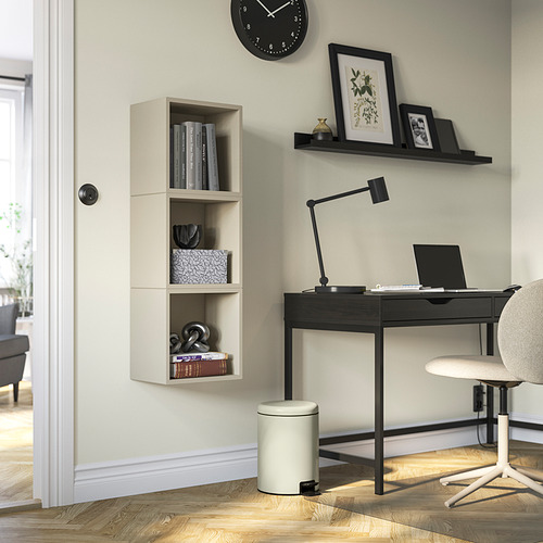 Despacho moderno en casa con escritorio minimalista, silla, lámpara, cubo y libros.