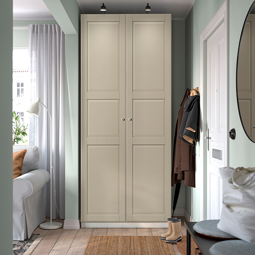 Moderno armario PAX gris con dos puertas, diseño minimalista, puerta casi blanca, espejo y silla.