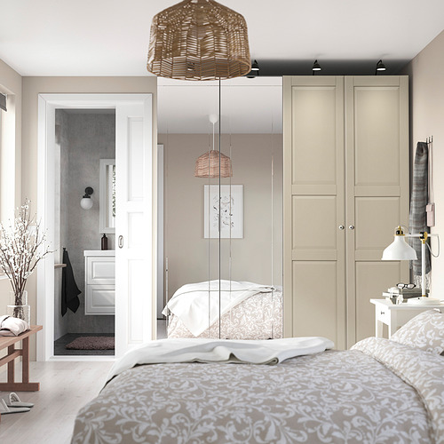 Acogedor dormitorio con ropa de cama floral, amplios armarios y baño abierto.