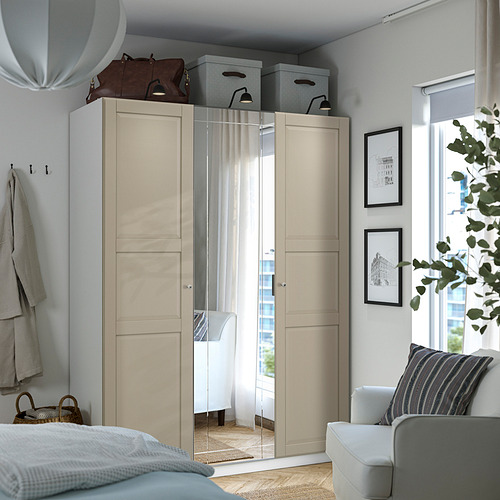 Moderno armario PAX blanco con puertas de espejo, de gran tamaño, ocupa rincón, guarda bolsos, ropa y decoración.