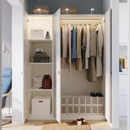 Armario organizado con ropa colgada, estantes y cajas de almacenamiento, con pies ajustables e iluminación integrada.