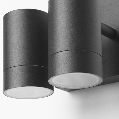 Moderna luminaria de pared negra con dos lámparas cilíndricas, que emiten un suave resplandor. Acabado metálico elegante y de alta calidad.