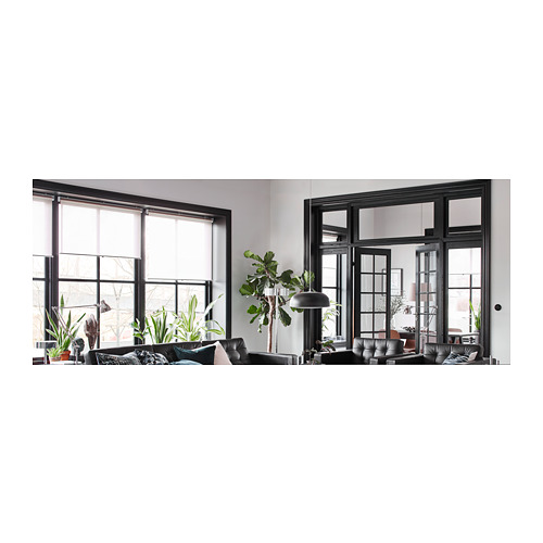 Sala de estar moderna con ventanas negras, sofá, plantas, acogedora y elegante.