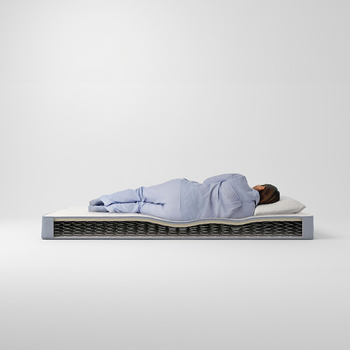 Persona durmiendo en un colchón VESTMARKA de color azul claro, con muelles de bonnell, con almohada blanca.