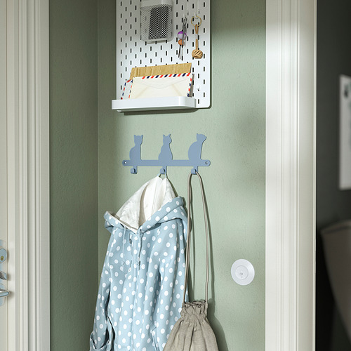 Los ganchos para niños con forma de gato sostienen la chaqueta y la bolsa.