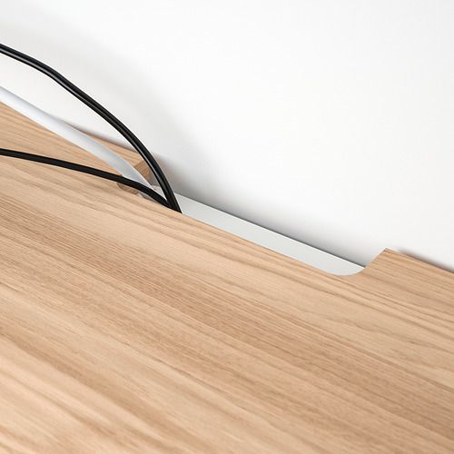 Tablero de madera con salida de cable negra fina, que protege los muebles y gestiona los cables de forma ordenada.