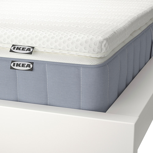Juego de colchones IKEA cuidadosamente dispuestos. Parte superior blanca, parte inferior estampada en azul claro. Etiqueta de IKEA visible.