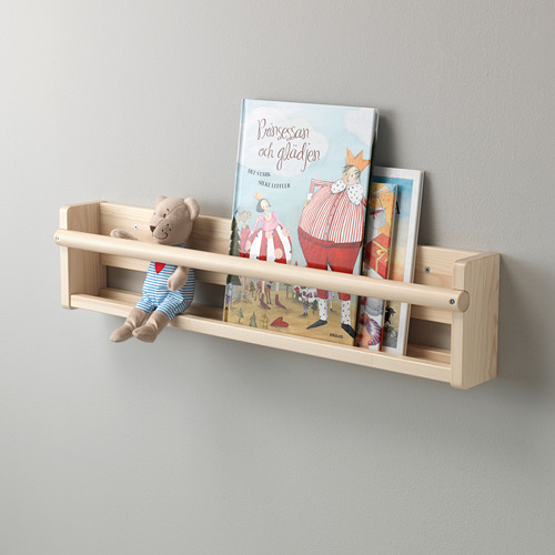 Un estante de pared de madera sostiene un osito de peluche y libros infantiles. El frente abierto permite un fácil acceso para los niños.