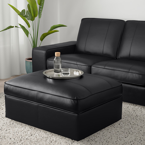 Salón moderno con sofá KIVIK, reposapiés a modo de mesa, planta.