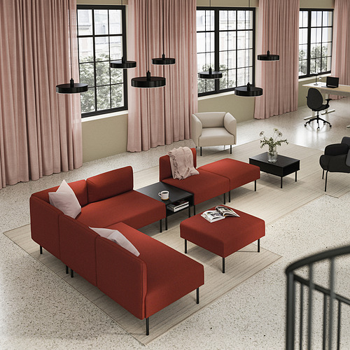 Sala de estar moderna con sofá LILLEHEM rojo, alfombra, mesas negras, lámparas colgantes, cortinas rosas y luz natural a través de grandes ventanales.