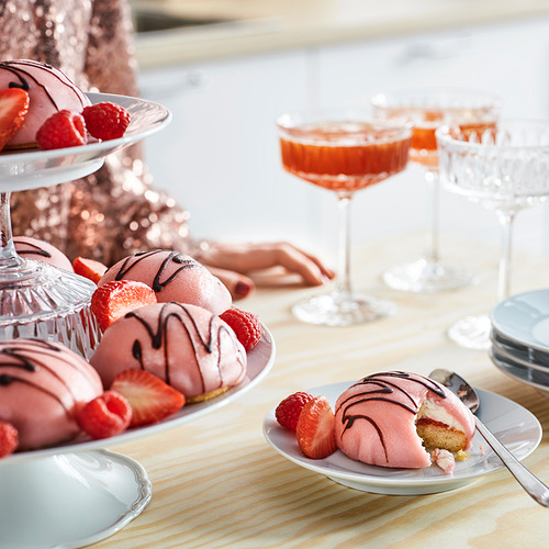 Tartas de crema rosa con fresas y frambuesas, cócteles y platos de postre.