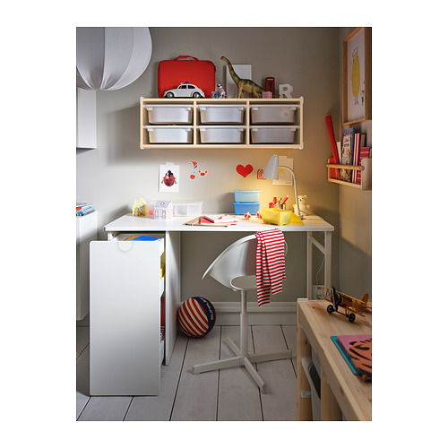 Zona de estudio para niños con escritorio LÄRANDE blanco, silla ajustable y muebles de almacenamiento, decorados con juguetes y libros.