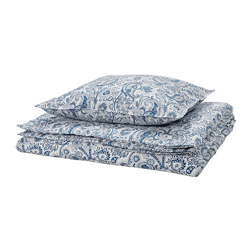 Un juego de cama de cama con estampado de cachemira azul y blanco, con funda nórdica y fundas de almohada, cuidadosamente dobladas.