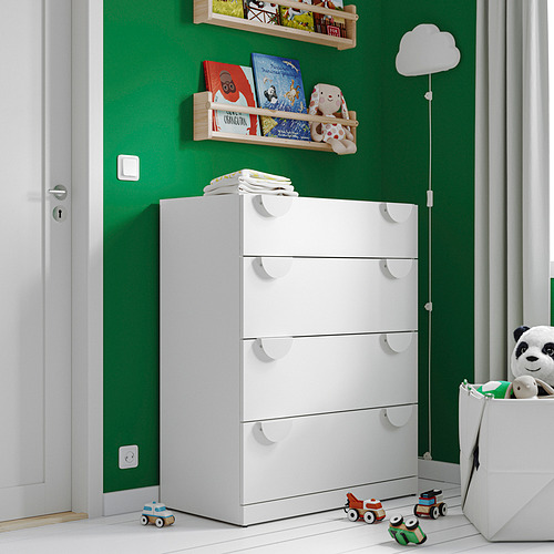 Una cómoda blanca LASTARE de 4 cajones en un casero con juguetes y libros alrededor.