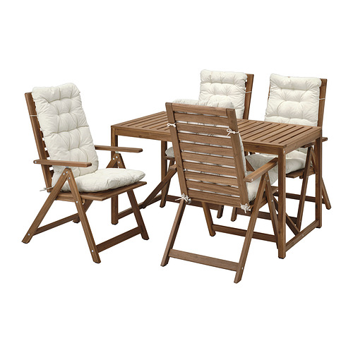 Cuatro sillas y un conjunto de muebles de mesa, realizados en madera de acacia marrón con cojines blancos, pensados para su uso en exteriores.