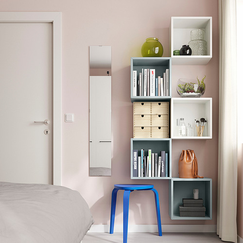 Dormitorio moderno con paredes rosas, almacenamiento EKET, libros, jarrones, maquillaje, taburete azul.