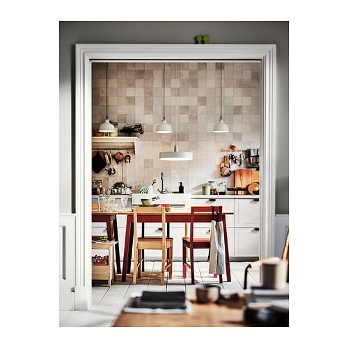 Acogedora cocina con mesa de madera roja, pisos cálidos y luces modernas.