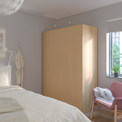 Dormitorio moderno con gran armario PAX, percheros, cama, lámpara, silla y ventana con persianas.