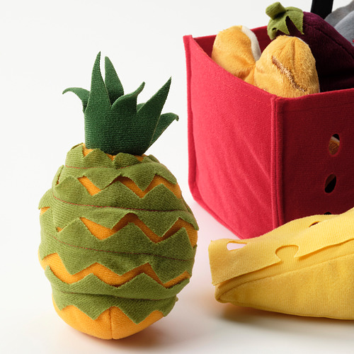 Piña de peluche con colores brillantes y costuras detalladas, junto a una cesta de la compra de peluche con comida de juego.