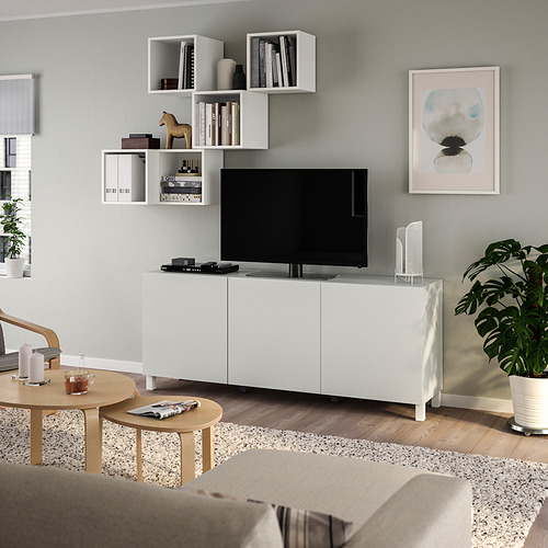 Sala de estar moderna con mueble de televisión BESTÅ, sofá beige y planta de interior.