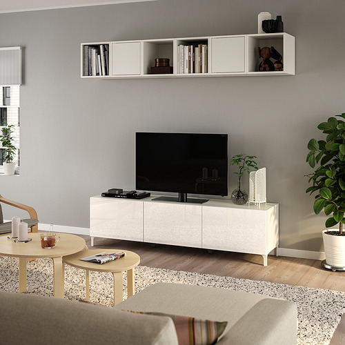 Banco de televisión BESTÅ con almacenamiento, mesas de madera, sofá gris en la sala de estar moderna.