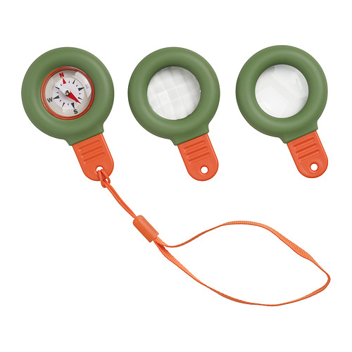 Tres brújulas verdes con bases y mangos naranjas, dos con lentes transparentes, una con esfera de brújula, conectadas por una correa naranja.