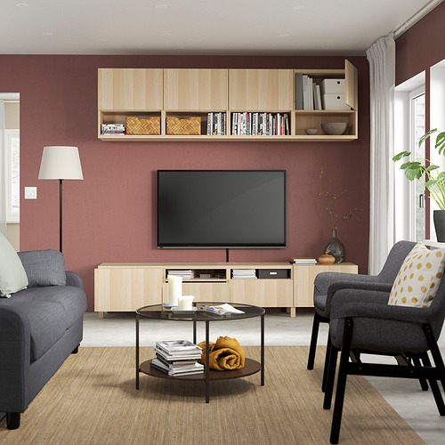 Sala de estar moderna con paredes granates, sofá gris, sillón y almacenamiento de tv BESTÅ.