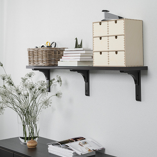Estante de pared que muestra cajas de almacenamiento, cesta de mimbre, libros y artículos decorativos.