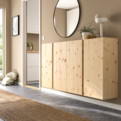 Mueble IVAR de madera, marrón claro, rectangular con puertas, cabe debajo de un gran espejo redondo, ligeramente más alto que la alfombra del suelo.