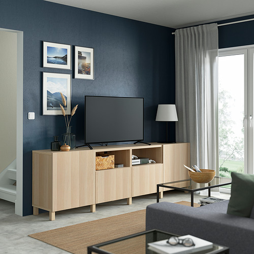 Sala de estar moderna con banco de tv BESTÅ, decoración, lámpara y sofá gris.