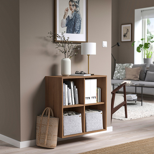 Mueble EKET de madera con lámpara, jarrón, cesta y sofá.