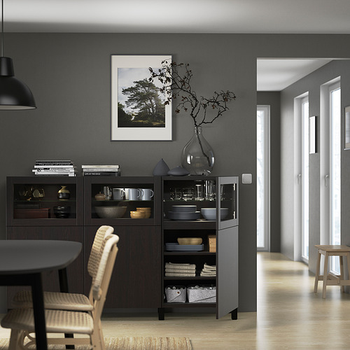 Comedor moderno con aparador oscuro, tazas, cuencos, toallas y decoración.