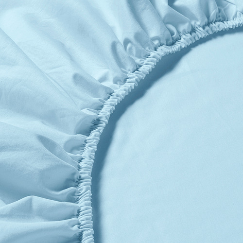 Primer plano de una sábana ajustable suave azul claro con bordes elásticos, que muestra su calidad y ajuste.