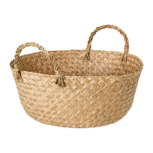 Cesta tejida a mano llamada SANDJORD en color junco natural, de forma circular con dos asas retorcidas para transportar. Un diseño rústico y natural.