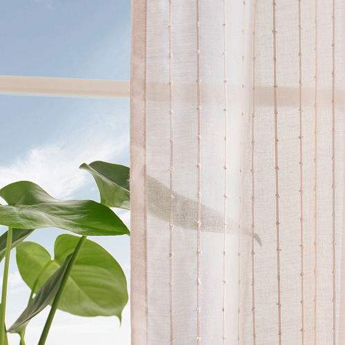 Las cortinas de color rosa pálido con rayas sutiles permiten la luz del día y brindan privacidad.