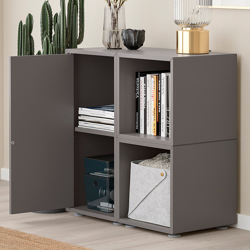 Moderno mueble de almacenaje gris con estantes abiertos para guardar libros y un compartimento cerrado. Estantes ajustables para un almacenamiento versátil.