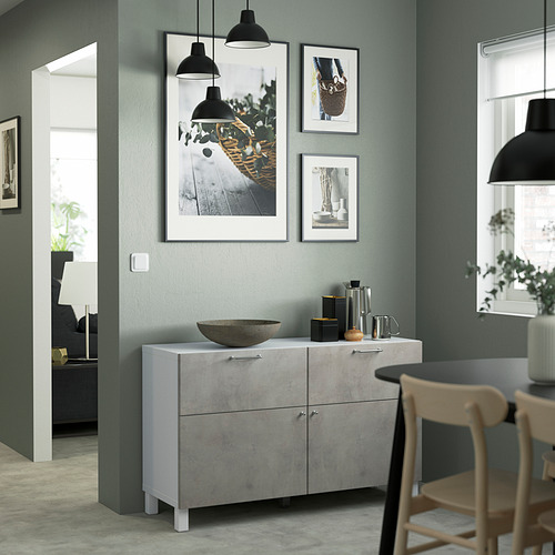 Sala de estar moderna con aparador BESTÅ, lámparas colgantes, cuadros enmarcados y elementos decorativos.