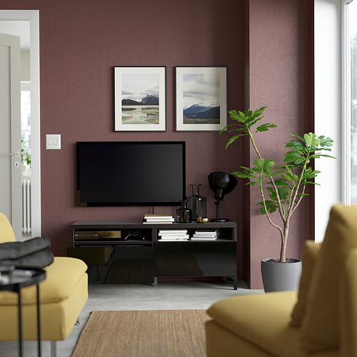 Sala de estar moderna con tv en soporte negro, silla amarilla y planta; paredes moradas y fotos de la naturaleza enmarcadas.