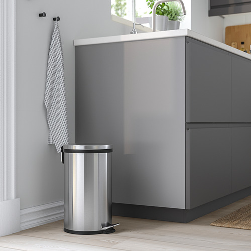 Papelera de plata en cocina moderna con armario gris y pared blanca. Fácil de mover con asa.