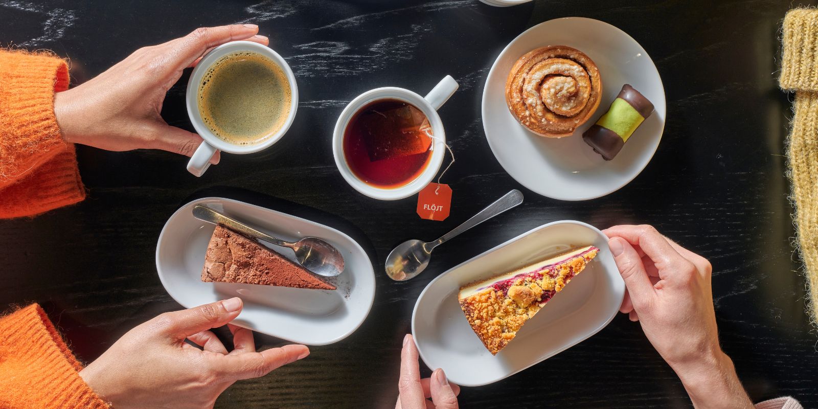 Pictured are coffee mugs, a teacup, a cinnamon roll, a chocolate cake, an apple-blueberry pie, and a white tray with the IKEA logo.