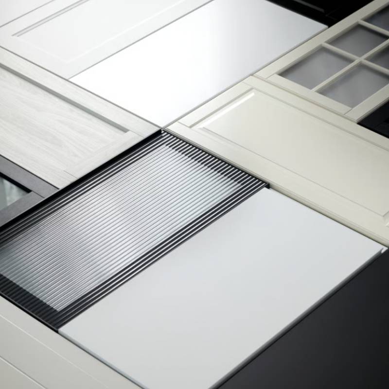 A number of kitchen fronts in dierent colours and expressions are placed together in a graphic pattern on a dark surface.