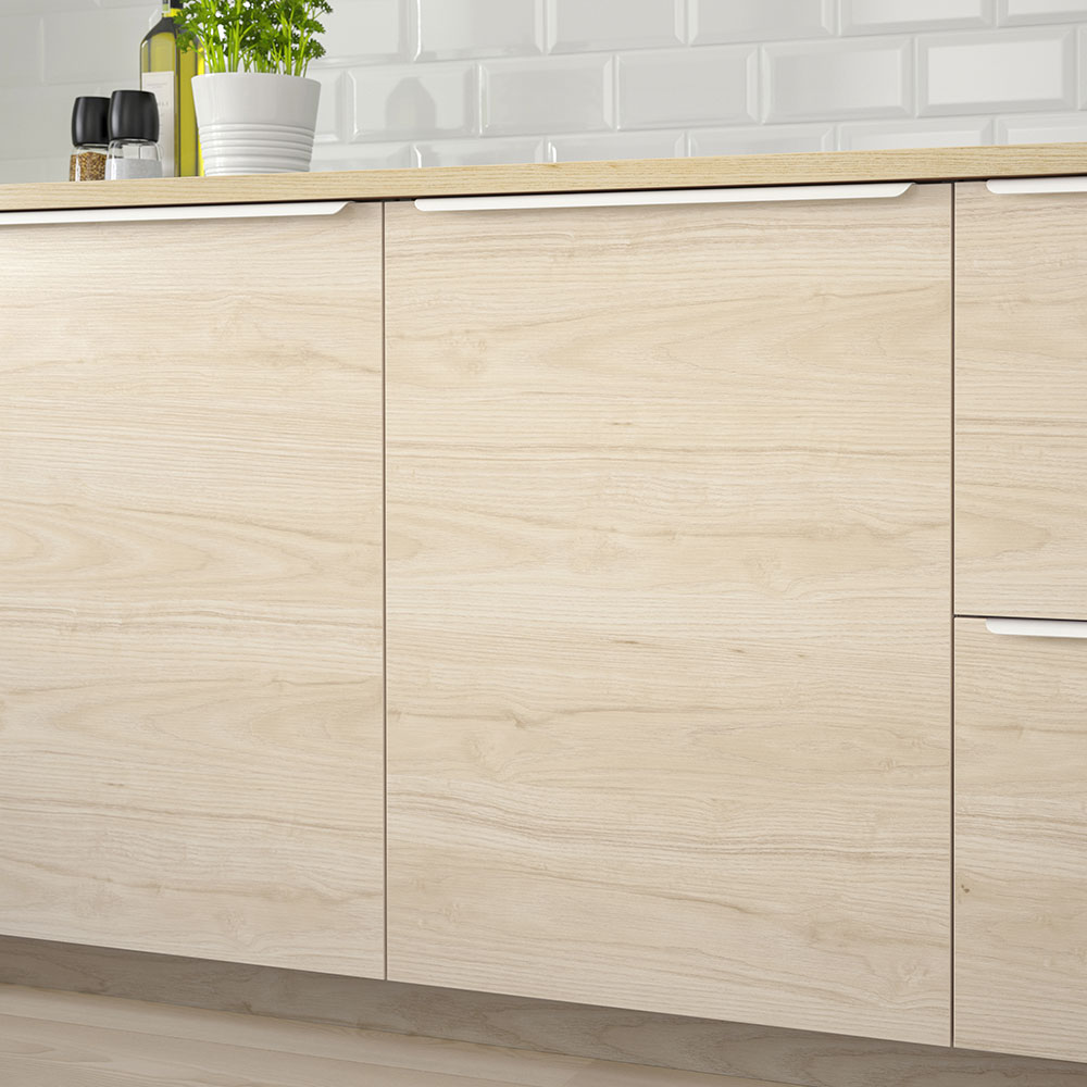 Low-angle view of a kitchen with pine wood lower cabinets, countertop, and faucet.